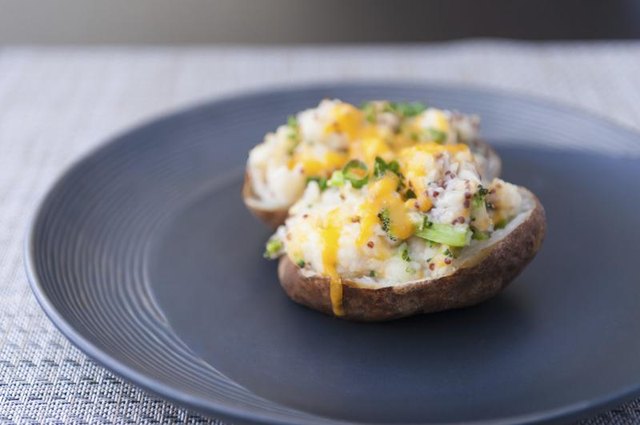 Plate with sliced baked potato on it.