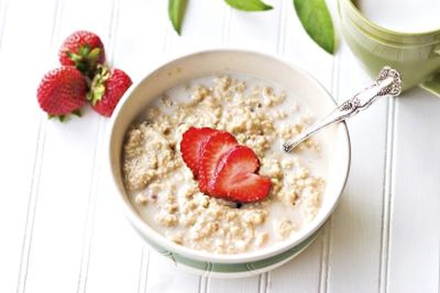 A bowl of oatmeal with strawberries.
