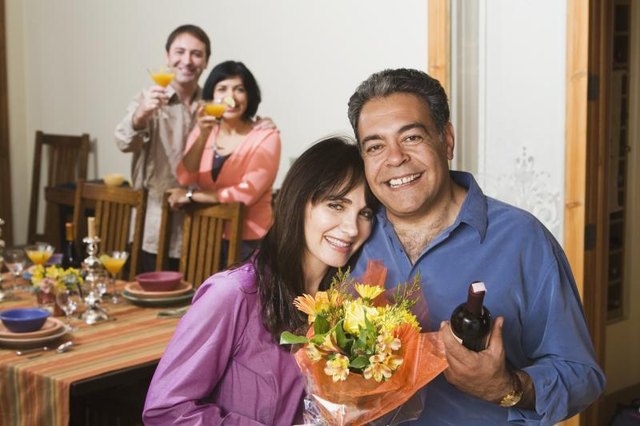 Older couple smiling at dinner party.