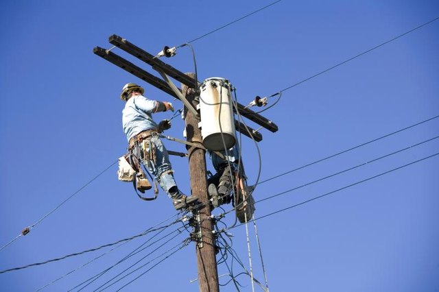 A utility worker repairs power lines.