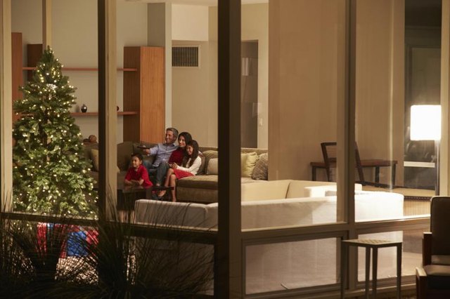 A family watching movie next to Christmas tree