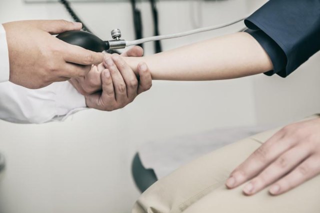 Doctor checking a patient's blood pressure.