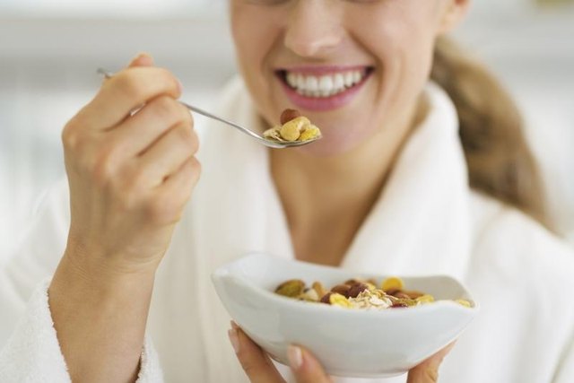 A close-up of a woman eating cereal in the morning.