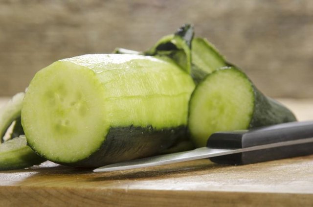 Peeled cucumber on cutting board.