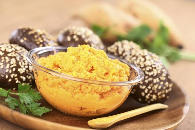 A plate of mashed sweet potatoes and buns.