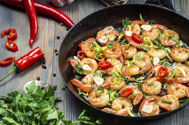 Grilled shrimp with herbs in a pan.