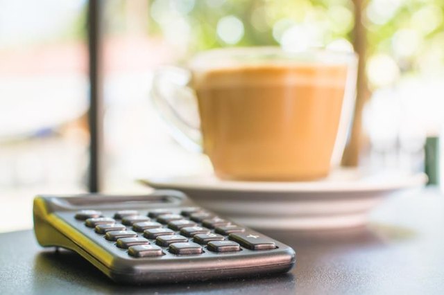 Calculator next to a cup of coffee