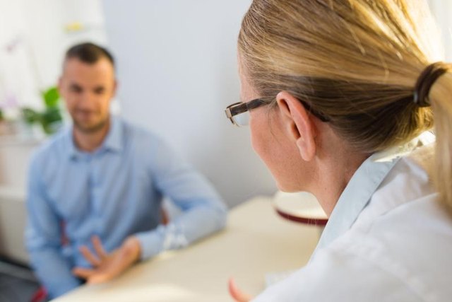 A man talking to his doctor at a desk.