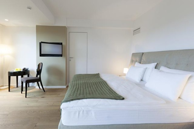 A modern bedroom interior with layered lighting.