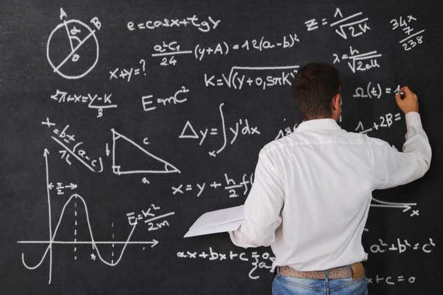 A man writes signs and symbols in mathematics on a chalkboard. A man writes signs and symbols in mathematics on a chalkboard.