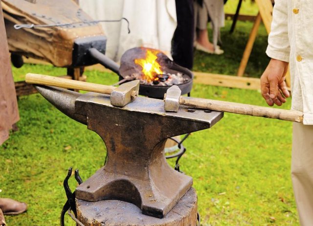 A traditional anvil with hammers ready to be used