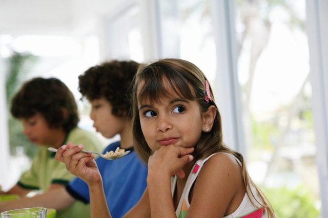Child eating outside at banquet table. Child eating outside at banquet table.