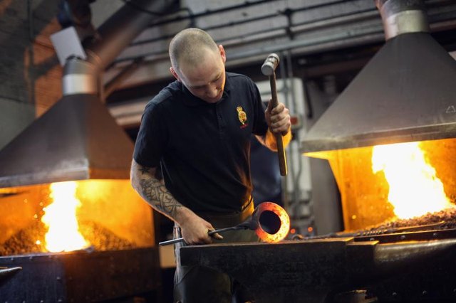 Man creating a horse shoe at foundry Man creating a horse shoe at foundry