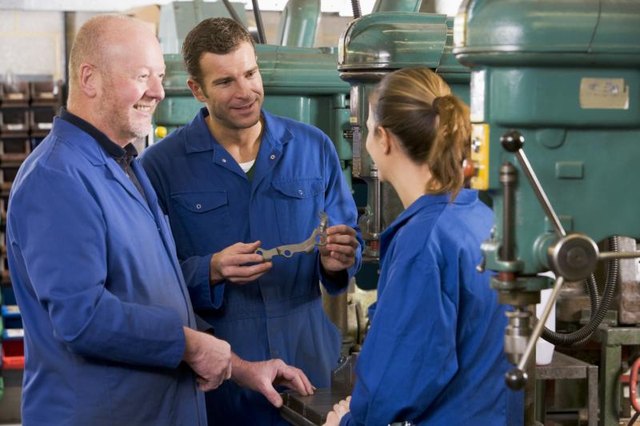 Three machinists talking at work. Three machinists talking at work.