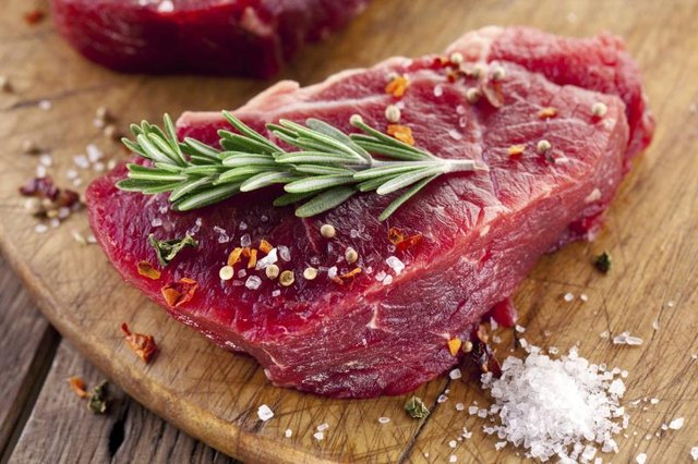 Raw beef steak with herbs and spices. Raw beef steak with herbs and spices.