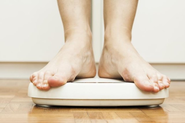 Feet standing on a bathroom scale. Feet standing on a bathroom scale.