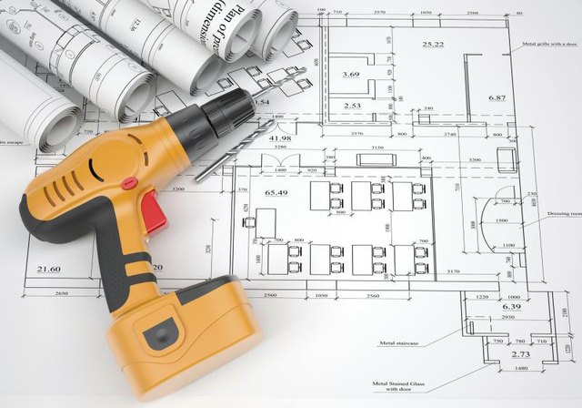 An electric screwdriver sitting on architectural plans. An electric screwdriver sitting on architectural plans.