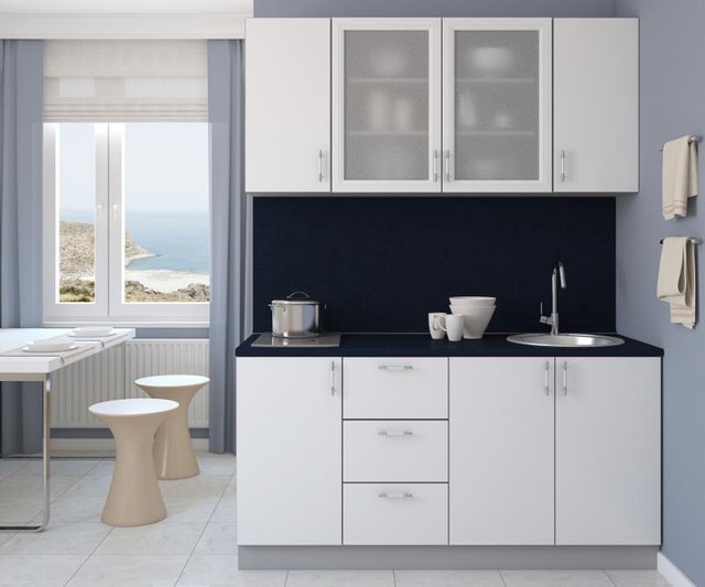 A small, compact kitchen in a studio. A small, compact kitchen in a studio.