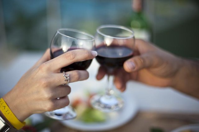 A couple toasting with wine glasses at a table for two. A couple toasting with wine glasses at a table for two.