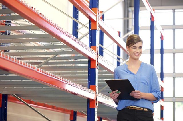 Woman with a clipboard in a warehouse. Woman with a clipboard in a warehouse.