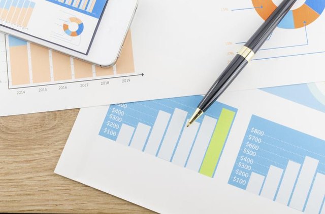 An overhead view of data charts, graphs and a pen on a desk. An overhead view of data charts, graphs and a pen on a desk.