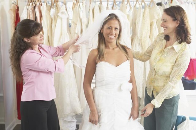 A happy bride-to-be is getting her wedding dress fitted. A happy bride-to-be is getting her wedding dress fitted.