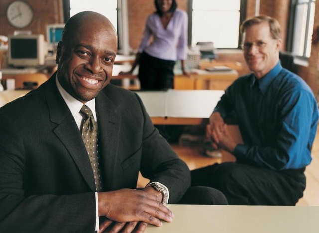 Three professionals working together in an office. Three professionals working together in an office.