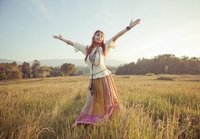 Hippie woman dancing in field Hippie woman dancing in field