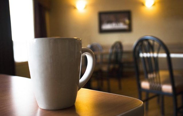 A white coffee mug on a cafe counter. A white coffee mug on a cafe counter.