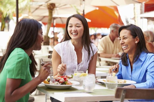 Group of women share a laugh during lunch Group of women share a laugh during lunch