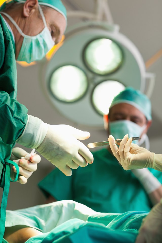 A surgen reaches for a scalpel during a surgery. A surgen reaches for a scalpel during a surgery.