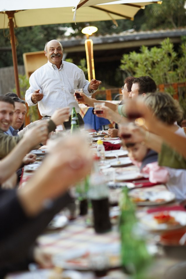 A man makes a toast at a family gathering. A man makes a toast at a family gathering.