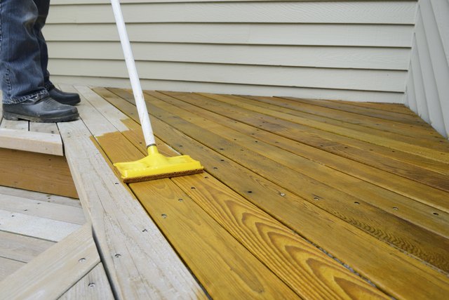 Worker staining a deck.