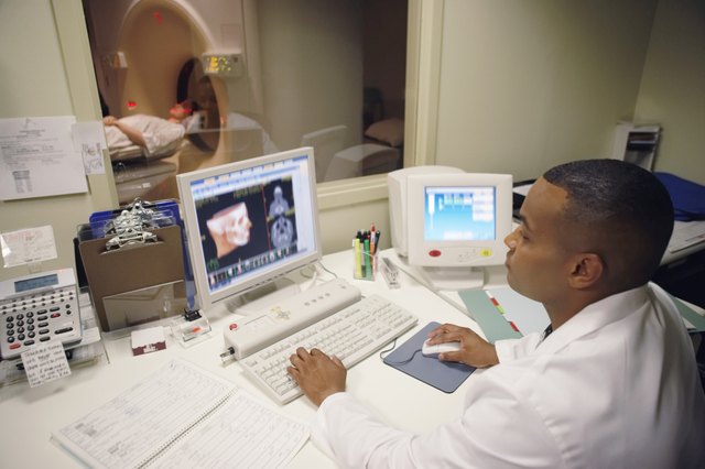 Technician looking at MRI on computer screen