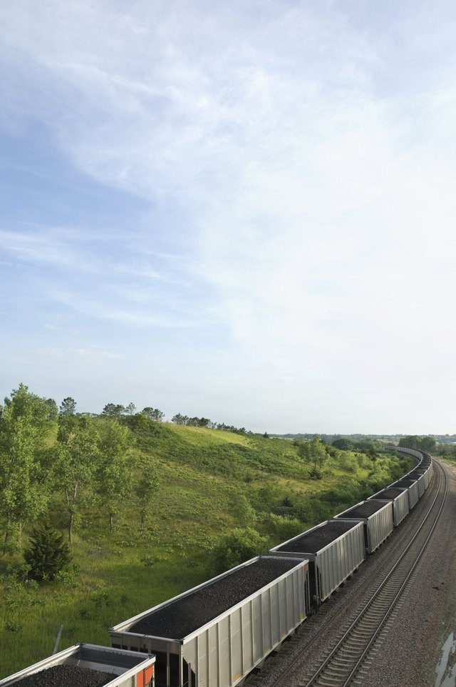 A train is carrying cars full of coal. A train is carrying cars full of coal.