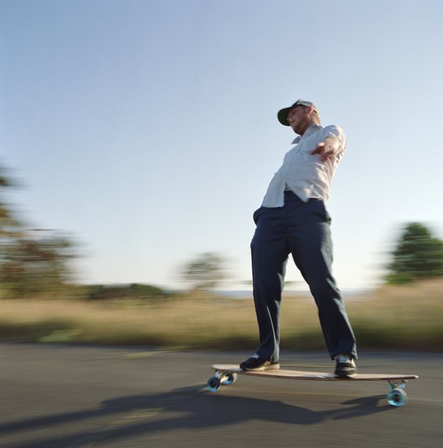 A skater cruises down a country road on a longboard. A skater cruises down a country road on a longboard.