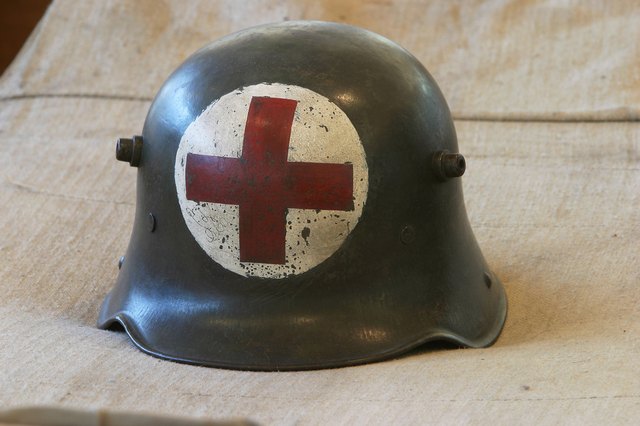 A military helmet with the Red Cross symbol on it.