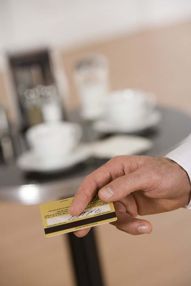 Close-up of man holding a credit card. Close-up of man holding a credit card.