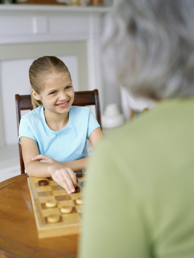 Little girl playing checkers with grandmother