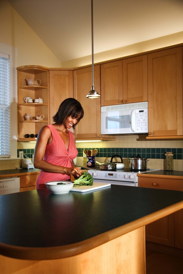 Woman cutting broccoli in the kitchen