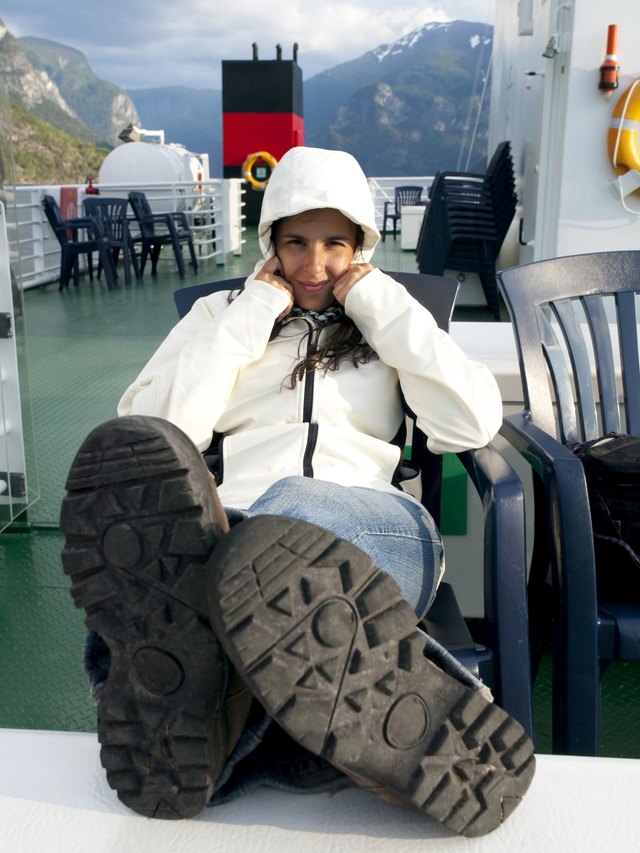 A woman wearing hiking shoes reclines with her feet up.