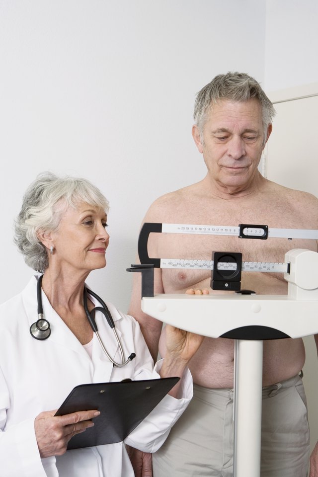 Senior man gets weighed by doctor Senior man gets weighed by doctor