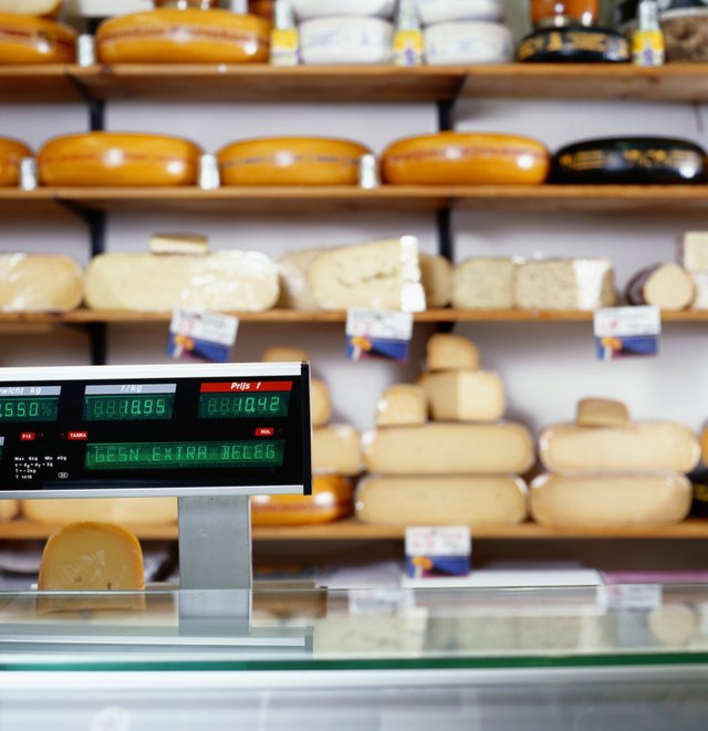 A variety of cheeses on display at a market.