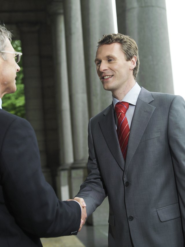 Man shaking hands in a gray suit