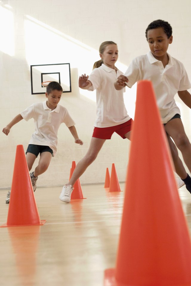Three students run through an obstacle course in gym class.