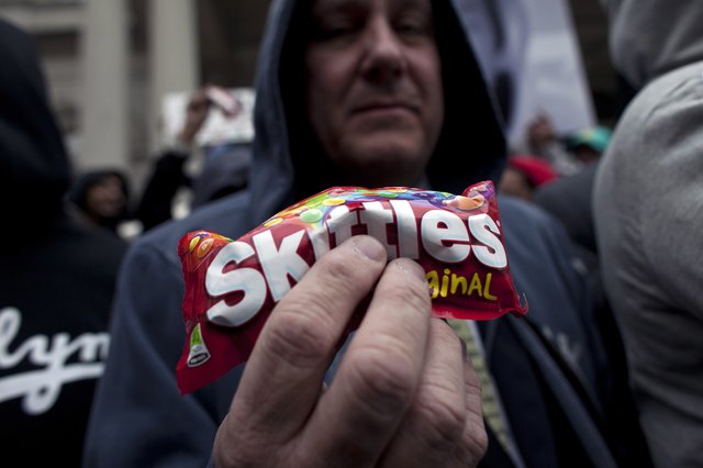 Hand holding a bag of Skittles