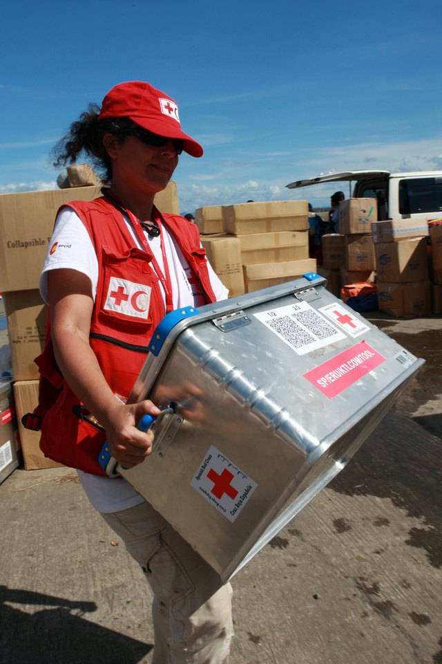 A Red Cross volunteer carries a first aid kit.