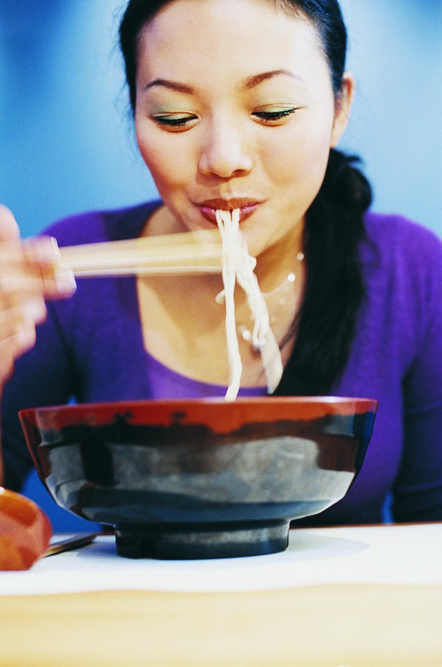 Woman eating ramen noodles
