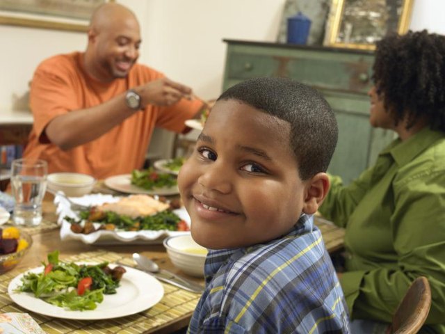 A family eating a healthy meal together at the dining room table.
