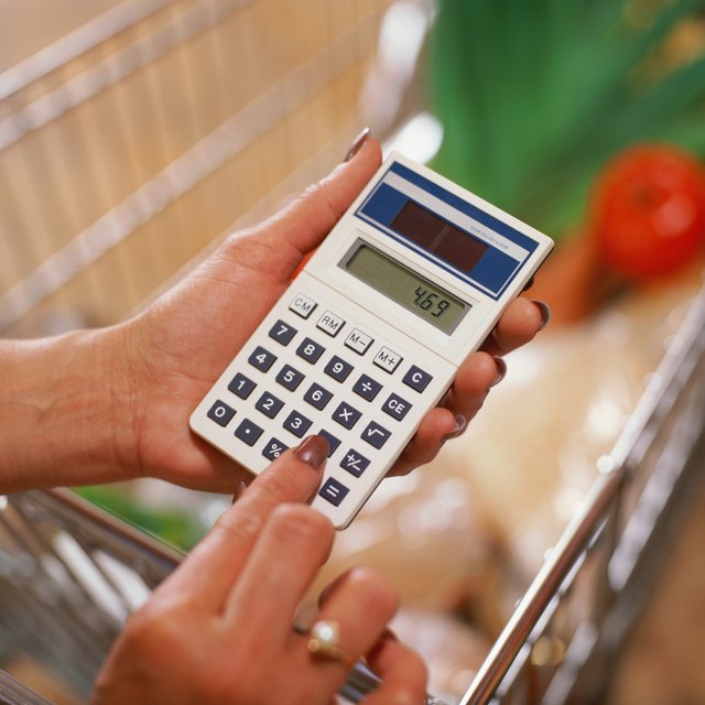 Close-up of woman using calculator.